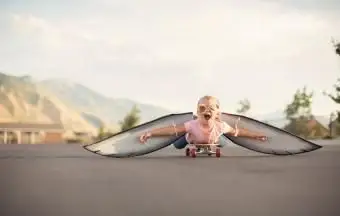 Fille avec des ailes sur la planche à roulettes