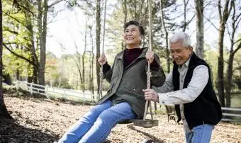 muž tlačí svou ženu na houpačce