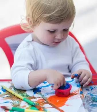 赤ちゃんが指を色に浸す