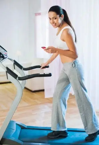 自宅でトレッドミルを歩く女性