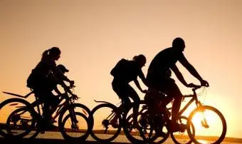 Familie beim Fahrradfahren bei Sonnenuntergang