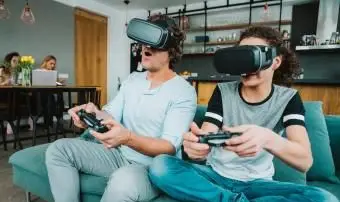 Vater und Teenager spielen VR-Spiel