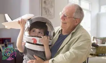 할아버지에 앉아 우주 헬멧을 쓴 소년