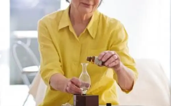 Femme âgée à l'aide d'un diffuseur d'huiles essentielles