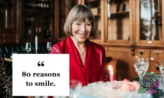 Mujer sonriendo mientras mira el pastel de cumpleaños