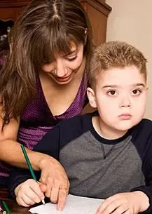 Une mère aide son fils autiste à faire ses devoirs