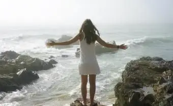 Kobieta stojąca na skalistym brzegu