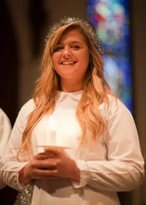 Fille en robe de Noël blanche, tenant une bougie