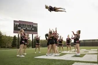 Équipe de cheerleading du lycée pratiquant sur le terrain de football