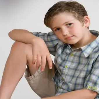 ילד בחולצה משובצת ומכנסיים קצרים