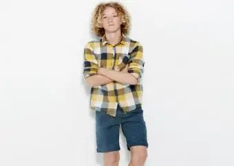 ילד בחולצה משובצת ומכנסיים קצרים