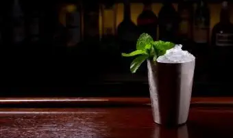 Coquetel Mint Julep servido em xícara metálica tradicional