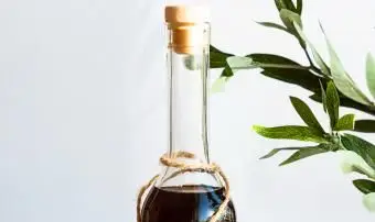 Uma garrafa de bebida à base de rum com um ramo de oliveira verde