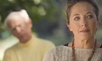 Une femme triste, un homme flou en arrière-plan