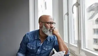 dojrzały mężczyzna siedzący przy oknie