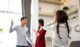 Dcéra sa pozerá na rodičov, ktorí sa v dome bijú