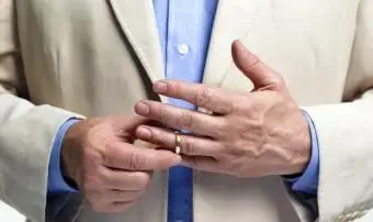 Rozvedený muž snímajúci snubný prsteň