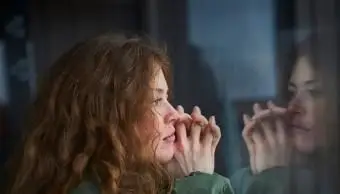 mulher olhando pela janela