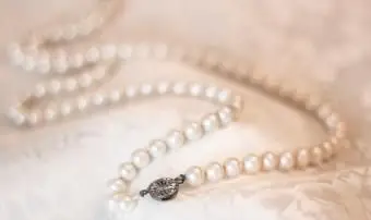 Collier de perles vintage sur tissu satiné fleuri