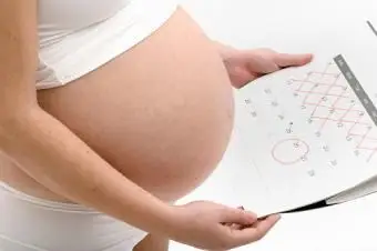 Tehotná žena drží kalendár