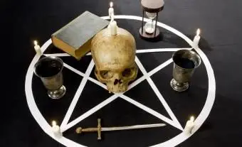 פנטגרם / מחומש עם נרות וגולגולת אנושית על רקע קטיפה