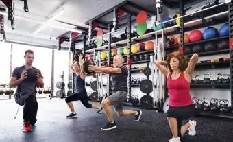 Seniori s osobným trénerom v telocvični cvičiť