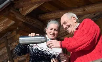 丸太小屋のバルコニーに立っている年配のカップル