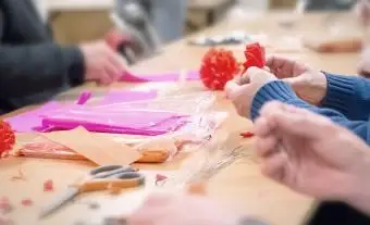 高齢者はクレープ紙の装飾を製造しています