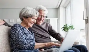 coppia di anziani che usa il laptop