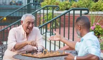 Amici che giocano a scacchi in giardino