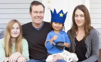 Familie mit Adoptivkind posiert und lächelt