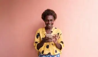 携帯電話で笑っている女性