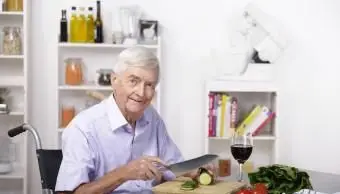 サラダを準備する年配の男性