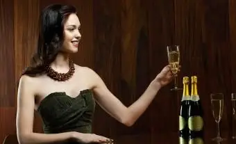 femme assise à table avec du champagne