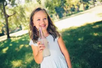 Kind mit Getränk in der Flasche im Park