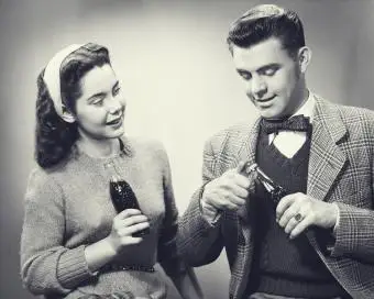 Junges Paar hält Flaschen Cola im Studio