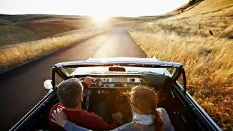 pár jízdy v kabrioletu západ slunce na obzoru