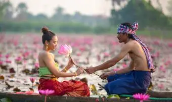 Homme donnant Lotus à une femme sur un bateau dans le lac