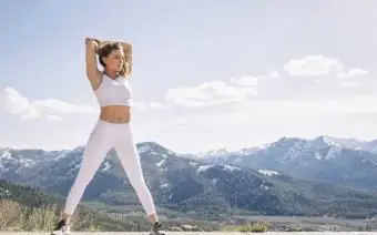 Młoda kobieta ćwicząca w górskim otoczeniu