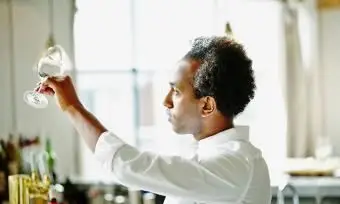 Camarero examinando copa de vino