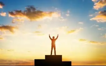 Uomo con le braccia alzate in segno di trionfo