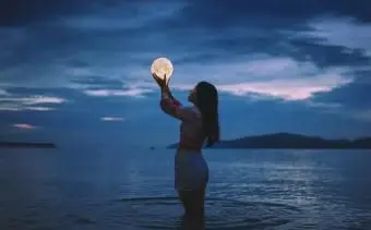 optická ilúzia ženy držiacej mesiac