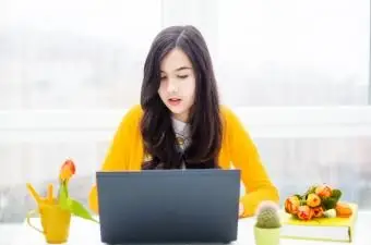 Dievča na sebe žlté posedenie s notebookom