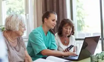 Zdravotná sestra so staršími ženami, ktoré kupujú lieky online
