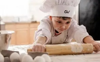 Junge rollt Teig aus