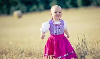 Holčička s dirndl se směje na strništi