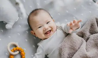 bambina che sorride dolcemente mentre giaceva sul presepe