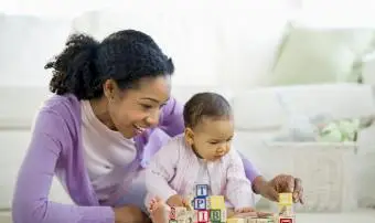 Žena si hraje s bloky s holčičkou