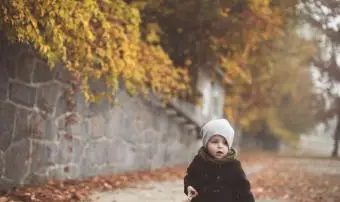 ילדה קטנה וחמודה נהנית בעונת הסתיו