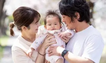 Mladá rodina s holčičkou a třešňovými květy